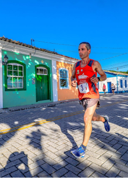 Sidney correndo com casas coloridas atrás